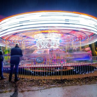 Long exposure of colourful carousel spinning at night at VanDusen Garden Festival of Lights decorated by Christmas lights